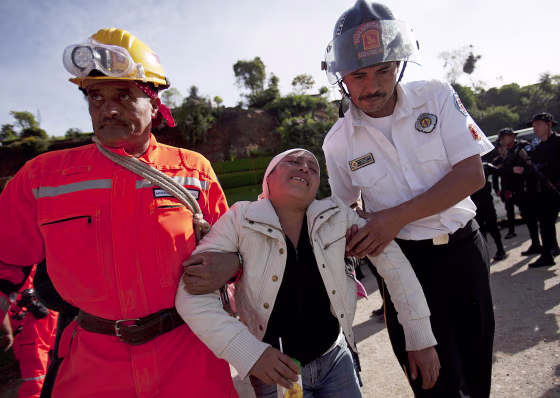 Members of a rescue team help a relative of a missing person as authorities continue the search for victims & survivors of an earthquake in San Marcos, Guatemala, on Nov. 8, 2012.