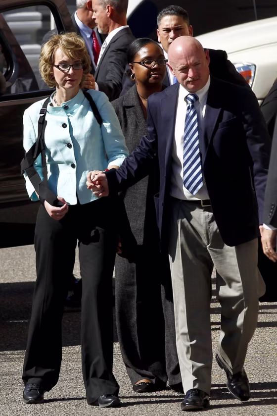Former Democratic Rep. Gabrielle Giffords, left, and her husband, Mark Kelly, leave U.S. District Court in Tucson, Ariz., on Thursday, Nov. 8, after the sentencing of Jared Loughner.