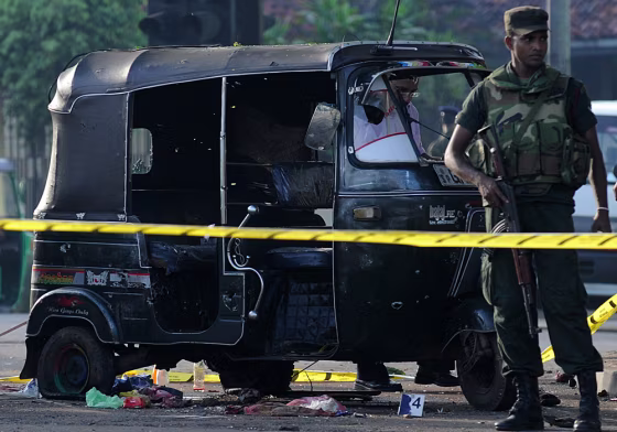 Sri Lankan soldiers stand guard near the three-wheel taxi allegedly used by inmates to escape from the Welika maximum prison in Colombo on Saturday, Nov. 10.