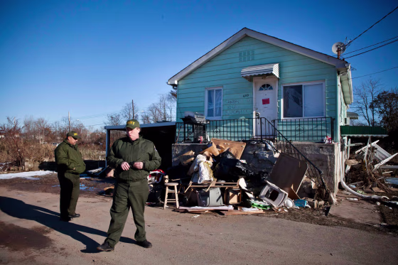 Department of Sanitation Workers survey the Midland Beach neighborhood where many homes are set to be demolished due to Hurricane Sandy in Staten Island, New York November 9, 2012.