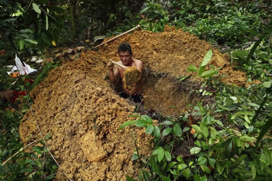 A 50-year-old grave digger who asked to be identified as Mr Sim exhumes a grave at Bukit Brown cemetery in Singapore on November 27, 2012.
