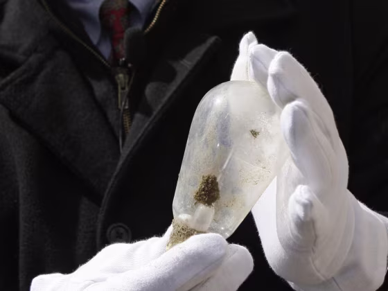 Andy Fisher, a systems engineer for GE, holds up a century-old light bulb placed next to a time capsule buried 100 years ago at GE's Lighting's Nela P...