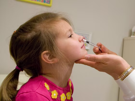 A child gets a FluMist influenza vaccine. CDC says vaccinations last year kept 79,000 people out of the hospital.