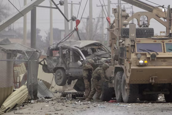 U.S. trucks lift a bomb-damaged vehicle in Kabul, Friday.