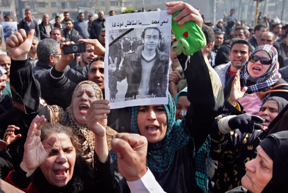 Egyptian relatives of Mohammed el-Gindy, a 28-year-old activist, who died early Monday protest the government during el-Gindy's funeral procession in Cairo on Monday. A medical report said el-Gindy's body showed marks of electrical shocks on his tongue, wire marks around his neck, smashed ribs, a broken skull and a brain hemorrhaging.