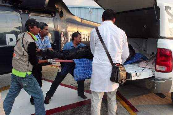 Forensic experts move the body of a federal agent in Michoacan, Mexico, on Tuesday. A high commander of the Federal Police said armed groups of the Los Cabelleros Templarios (The Templar Knights) cartel staged six attacks against agents who patrolled several state roads in Michoacan.