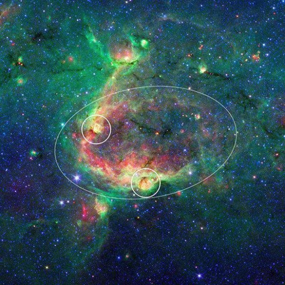 This infrared image shows a striking example of what is called a hierarchical bubble structure, in which one giant cosmic bubble, carved into the dust of space by massive stars, has triggered the formation of smaller bubbles.