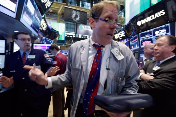 Trader Luke Scanlon, center, moves from post to post as he works on the floor of the New York Stock Exchange on Tuesday. Stocks fell in early trading ...