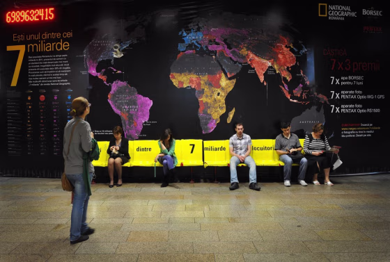 A counter approaches the 7 billion mark at a National Geographic exhibit in a subway station in Bucharest, Romania, highlighting global population density.