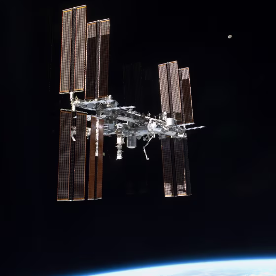 The International Space Station looms above Earth during the unorthodox Atlantis fly-around on July 19. The moon can be seen above and to the right of the station.