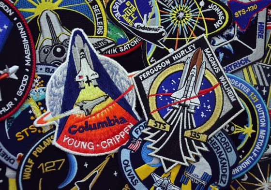 A collection of shuttle mission patches, including patches representing STS-1 (the first mission) and STS-135 (the last), can be an inexpensive way to keep spaceflight memories alive.