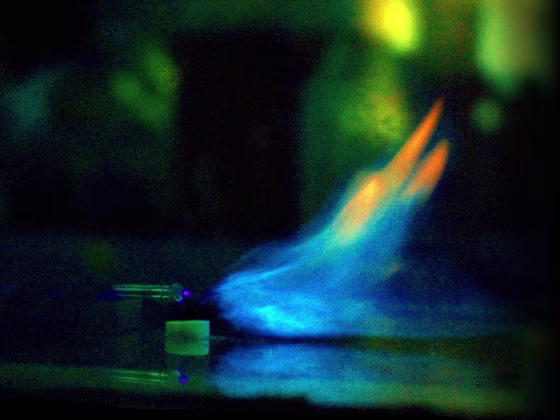 A methane flame shooting out from a burner is deflected by a wire electrode. Moments later, the flame went out.