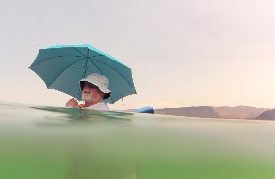 Mike Bouse of Henderson, Nev., shades himself with an umbrella as he floats in the waters along Boulder Beach at Lake Mead, June 29, near Boulder City, Nev. Bouse and his wife planned to spend most of the day in and out of the water to escape the heat in the Las Vegas area where Saturday's daytime high was expected to reach 117 degrees, the city's all-time high. It was 108 at noon Saturday in Sin City.