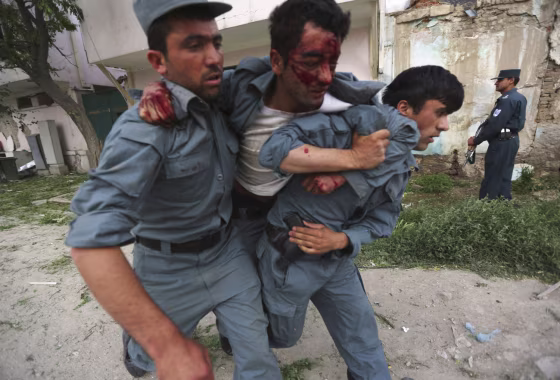 A wounded Afghan policeman is being carried away from the site of an explosion in Kabul on May 24, 2013.
