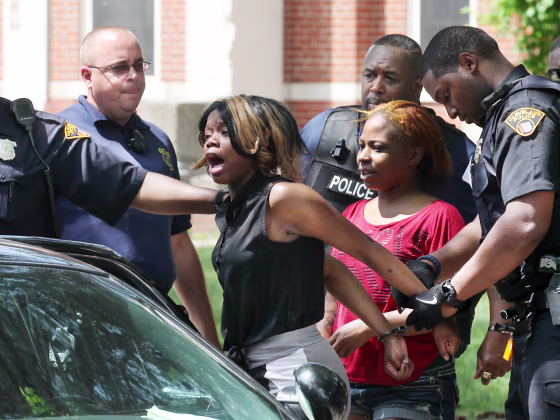 Cleveland police arrest a woman involved with a fight that broke out at Michael R. White Elementary school after a kindergarten graduation ceremony on Friday in Cleveland.