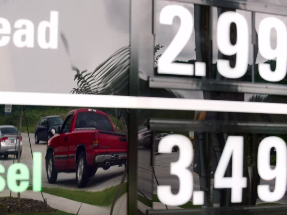 In this Monday, July 1, 2013, photo, vehicles are reflected in a sign advertising unleaded gas for $2.99 at a QuikTrip station at the corner of Woodr...