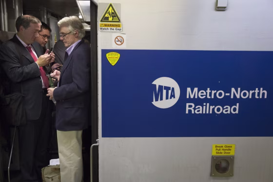 Commuters stand in the doorway of a Stamford-bound train at Grand Central Terminal as transit on the New Haven line runs on limited capacity on Sept. 25 in New York.