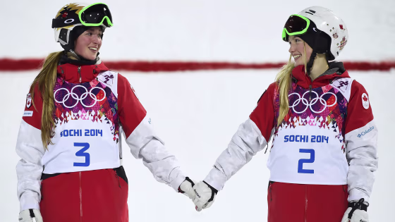 Second-placed Chloe Dufour-Lapointe (L) of Canada and her sister, first-placed Justine Dufour-Lapointe (R), hold hands during the flower ceremony for ...