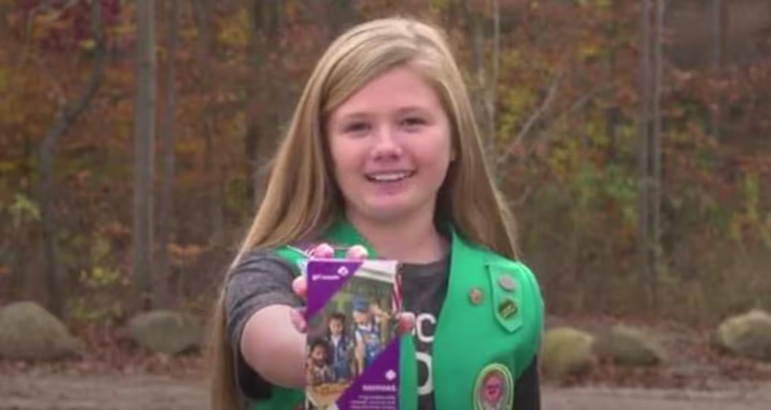 McKenna Moore with a box of Girl Scout Cookies.