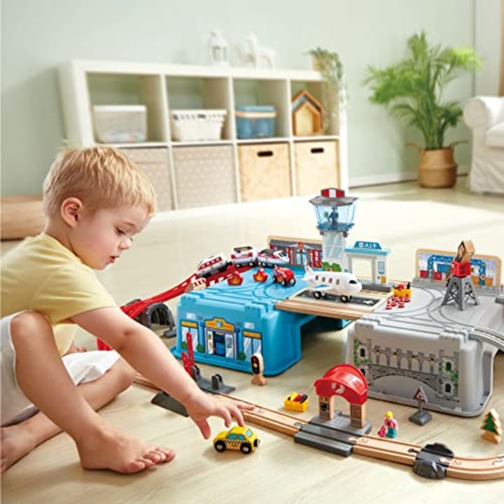 Hape Super Cityscape Transport Bucket Set | Wooden Toy Train Set with City Scenes, Plane, Battery-Powered Engine, for Children 3+ Years