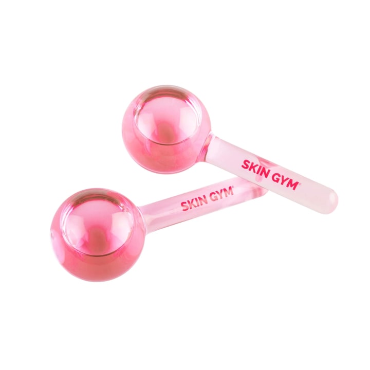 Two Skin Gym Cryocicles Pink Facial Ice Globes on a white background.