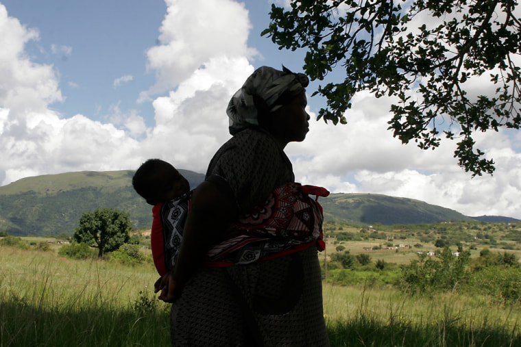 **ADVANCE FOR SUNDAY, APRIL 26**  In this photo taken on March 4, 2009, a Swazi woman carries a child on her back in Swaziland's Egebeni district.  Across Africa and elsewhere in the developing world, ancient traditions and modern circumstances have combined to place the burden on putting food on poor families' tables on women. (AP Photo/Denis Farrell)