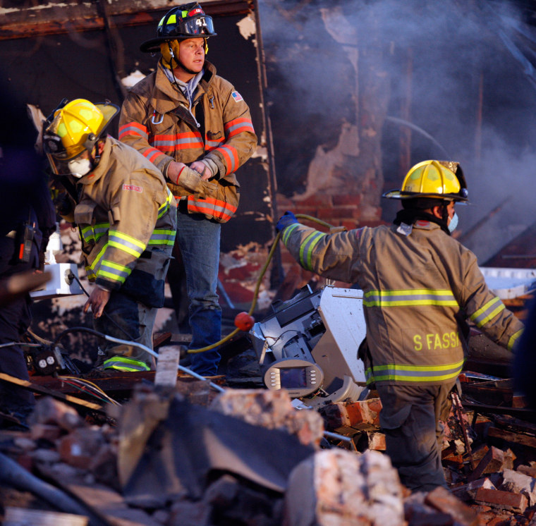 Image: Firefighters search through the rubble of a restaurant