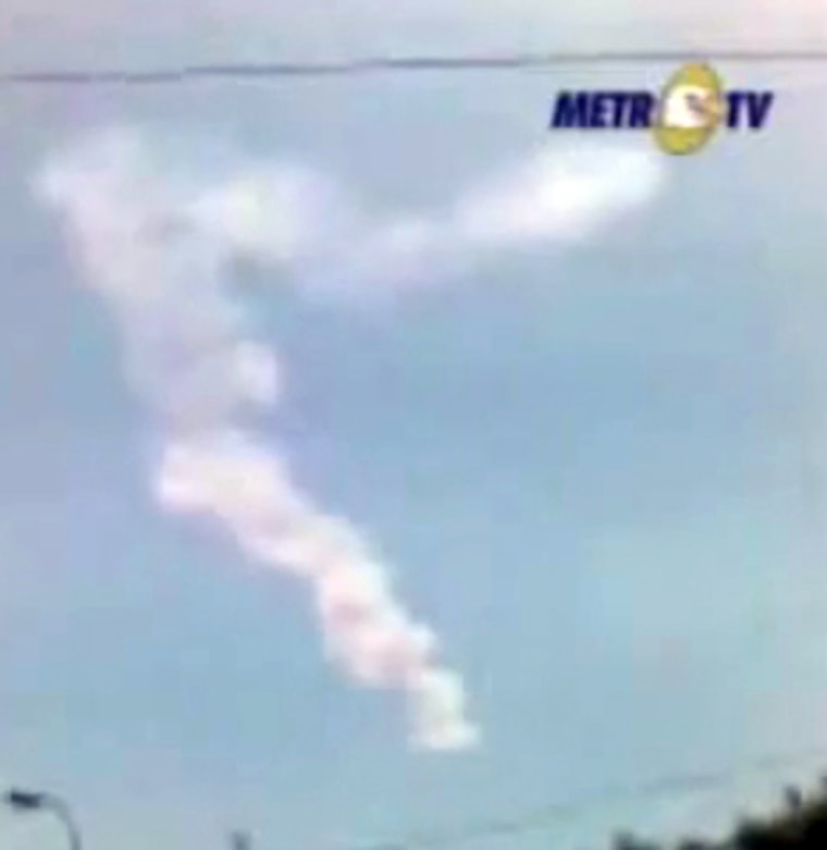 This still from an Indonesian newscast shows the remains of an asteroid explosion over Indonesia as seen by an amateur videographer.