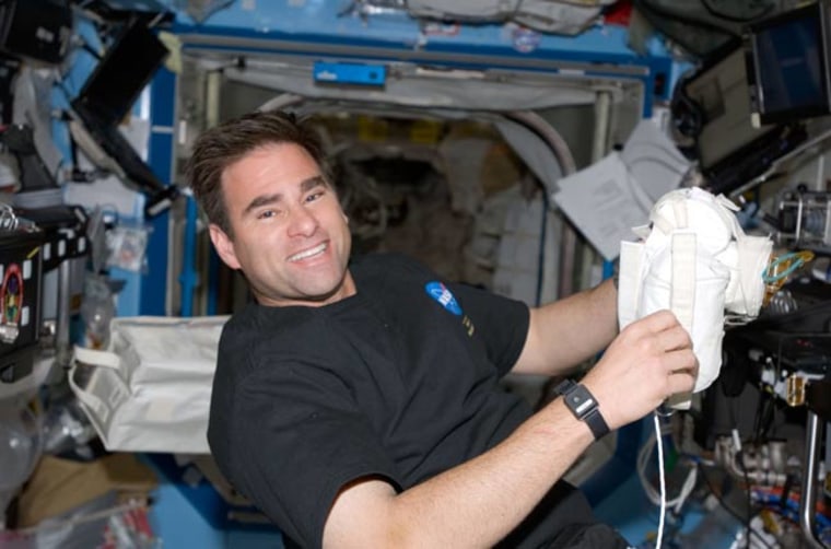 Astronaut Greg Chamitoff, Expedition 17 flight engineer, takes a moment for a photo as he works in the Destiny laboratory of the International Space Station while Space Shuttle Discovery is docked with the station. Credit: NASA.