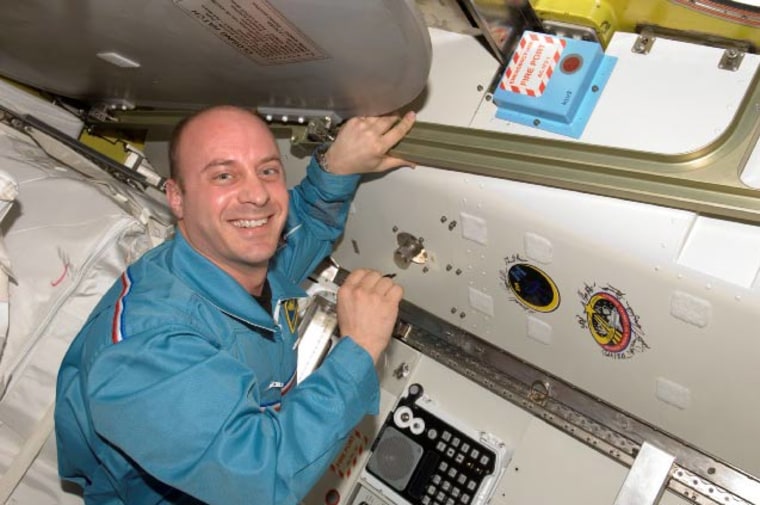 Astronaut Garrett Reisman, Expedition 16/17 flight engineer, poses for a photo after signing the Expedition 16 patch, which was added to the growing collection of insignias representing crews who performed spacewalks from the Quest Airlock of the ISS. Credit: NASA.