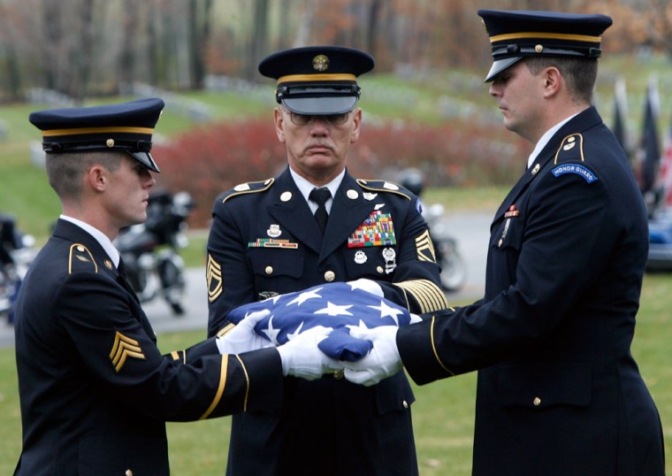 Image: An honor guard folds a flag during a ceremony