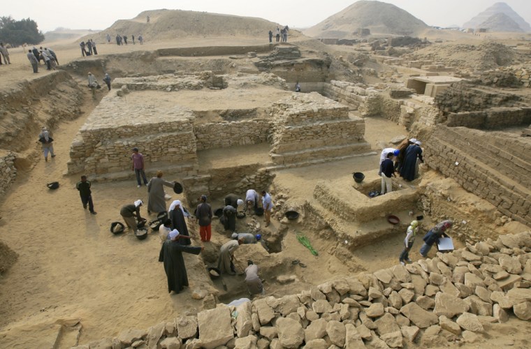Image: Egyptian archaeologists work at an ancient burial ground