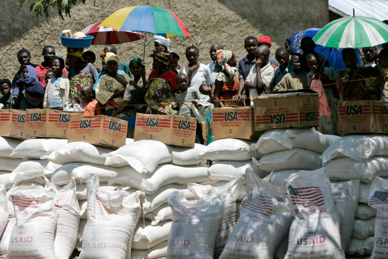 Image: Displaced people wait their turn to receive food aid