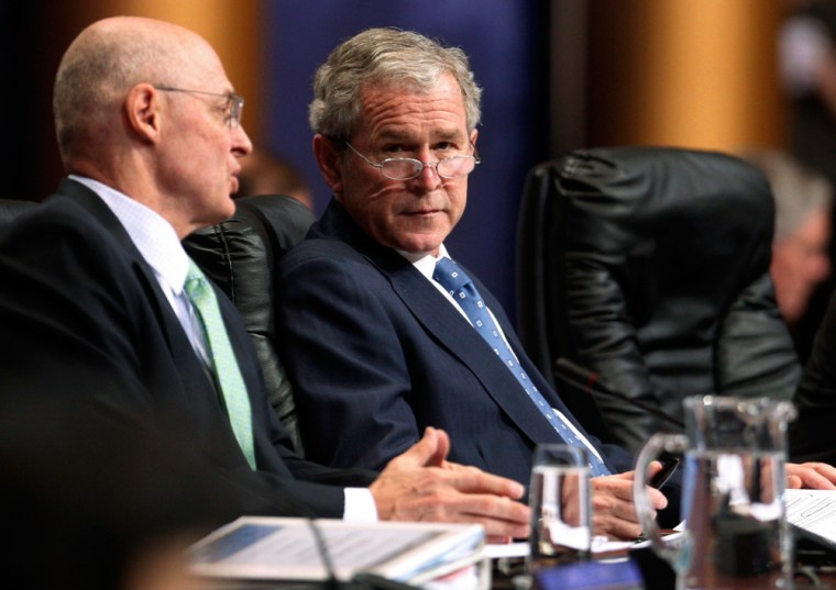 U.S. President George W. Bush listens to Treasury Secretary Henry Paulson during the First Plenary Session at the G20 Summit in Washington