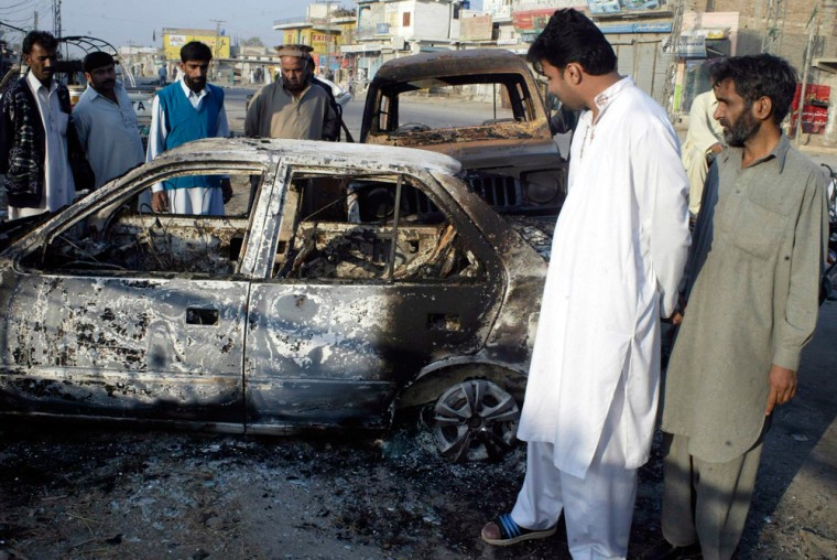 Image: People inspect a blast site in Dera Ismail Khan