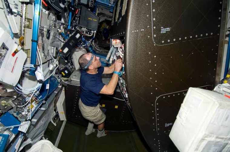 Endeavour astronaut Don Pettit works on the international space station's water recycling system on Nov. 19. The system suffered through some glitches after installation, but space station commander Mike Fincke said Tuesday's test was successful.