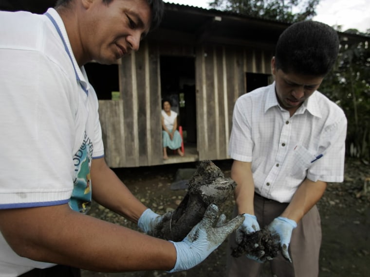 Donald Moncayo, left, and Pablo Fajardo extract mud that contains oil from the yard of Mercedes Jimenez, behind, in Lago Agrio, Ecuador, Aug. 4, 2008.  Ecuador's President Rafael Correa has sided squarely with the 30,000 plaintiffs, Indians and colonists, in a class-action suit, dubbed an Amazon Chernobyl by environmentalists, over the slow poisoning of a Rhode Island-sized expanse of rainforest with millions of gallons of oil and billions more of toxic wastewater. (AP Photo/Dolores Ochoa)