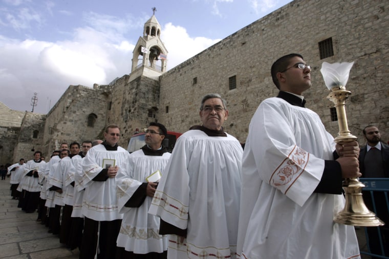 Image: Palestinian clergymen stand outside the Church of the Nativity in the Biblical West Bank town of Bethlehem