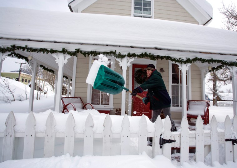Image: Susan Anderton of Crested Butte, Colo. shovels the snow from her fence and gate