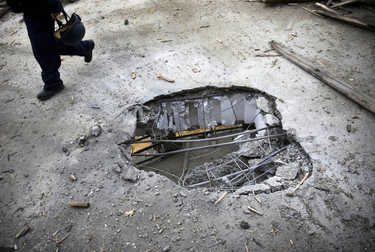 Image: A hole in the floor of a construction site where a rocket fired by Palestinian militants in Gaza hit