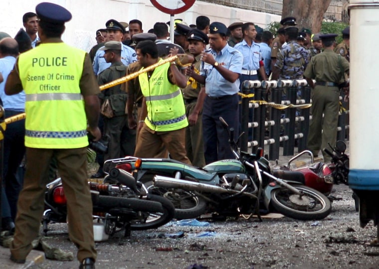 Image: Sri Lankan security personnel inspect the site of a suicide bomb explosion