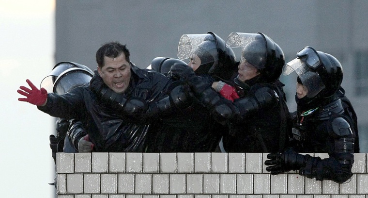 Police officers detain a protester on top of a building, where local residents protested against a redevelopment project, in Seoul on January 20, 2009.  Five people died in an apartment block blaze when riot police in the South Korean capital broke up a sit-in by protesting residents throwing firebombs, firefighters said.          REPUBLIC OF KOREA OUT NO INTERNET NO SALES NO ARCHIVES  GETTY OUT   AFP PHOTO (Photo credit should read YONHAP/AFP/Getty Images)