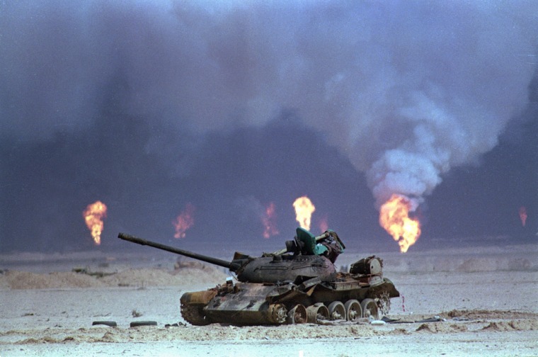 ** FILE ** A destroyed Iraqi tank rests near a series of oil well fires during the Gulf War, March 9, 1991, in northern Kuwait. As preparations for war intensify in the Persian Gulf, Kuwait is redoubling efforts to protect refineries and other centers of its lifeblood oil industry against an attack by neighboring Iraq. Iraqi troops looted, blew up and burned much of the country's oil infrastructure during the 1991 Gulf War. They sabotaged more than 700 wells, setting oil fields ablaze for nine months, and even stole drilling derricks.(AP Photo/David Longstreath)