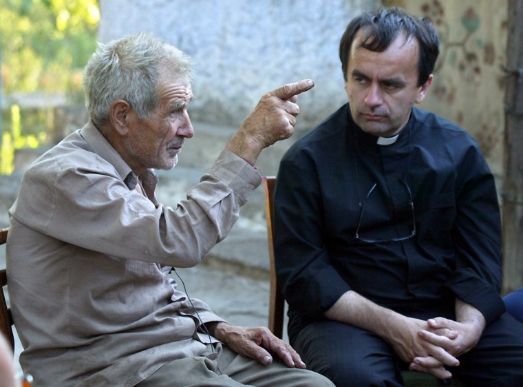 ** FILE ** In this July 15, 2007 file photo Anatoly Veliminchuk, left, speaks with french priest Patrick Desbois about the massacre of tens of thousands Jews he witnessed in the early years of the war in Bogdanivka, Ukraine. In his book \"The Holocaust by Bullets,\" Desbois uncovers a little known chapter of the Holocaust, the extermination of Eastern Europe's 2 million Jews by guns, by interviewing elderly victims of the tragedy and locating hundreds of mass graves strewn around dusty fields in the former Soviet Union. (AP Photo/Efrem Lukatsky, File)