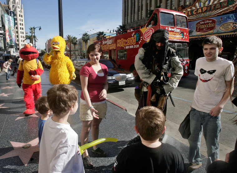 James Hill, a character actor portraying Captain Jack Sparrow, second from right, entertains a family of nine visiting from Wasilla, Alaska, on Hollywood Boulevard Jan. 27 in Los Angeles. 
