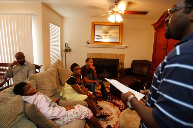 Unaji leads a discussion in his living room at an Obama House Party in Grand Prairie