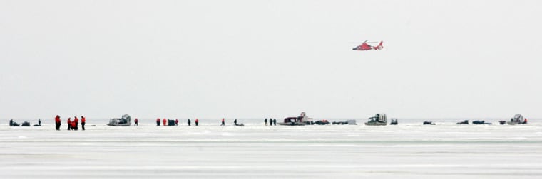 Image: A helicopter flies over fishermen stranded on a slab of ice about 8 miles wide that broke free and floated away from the Ohio shoreline of Lake Erie