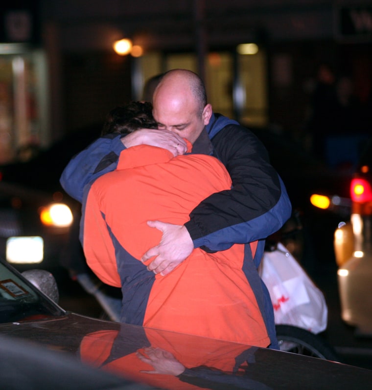 A man who said he is a relative consoled his wife outside the apartment building on Manhattan's Upper West Side in New York, where three bodies were found Saturday.