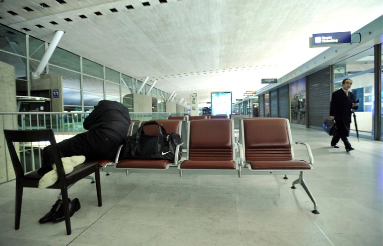 Image: A passenger sleeps inside Roissy Charles de Gaulle Airport