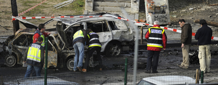 Image: Policemen inspect the area after a van loaded with a bomb exploded
